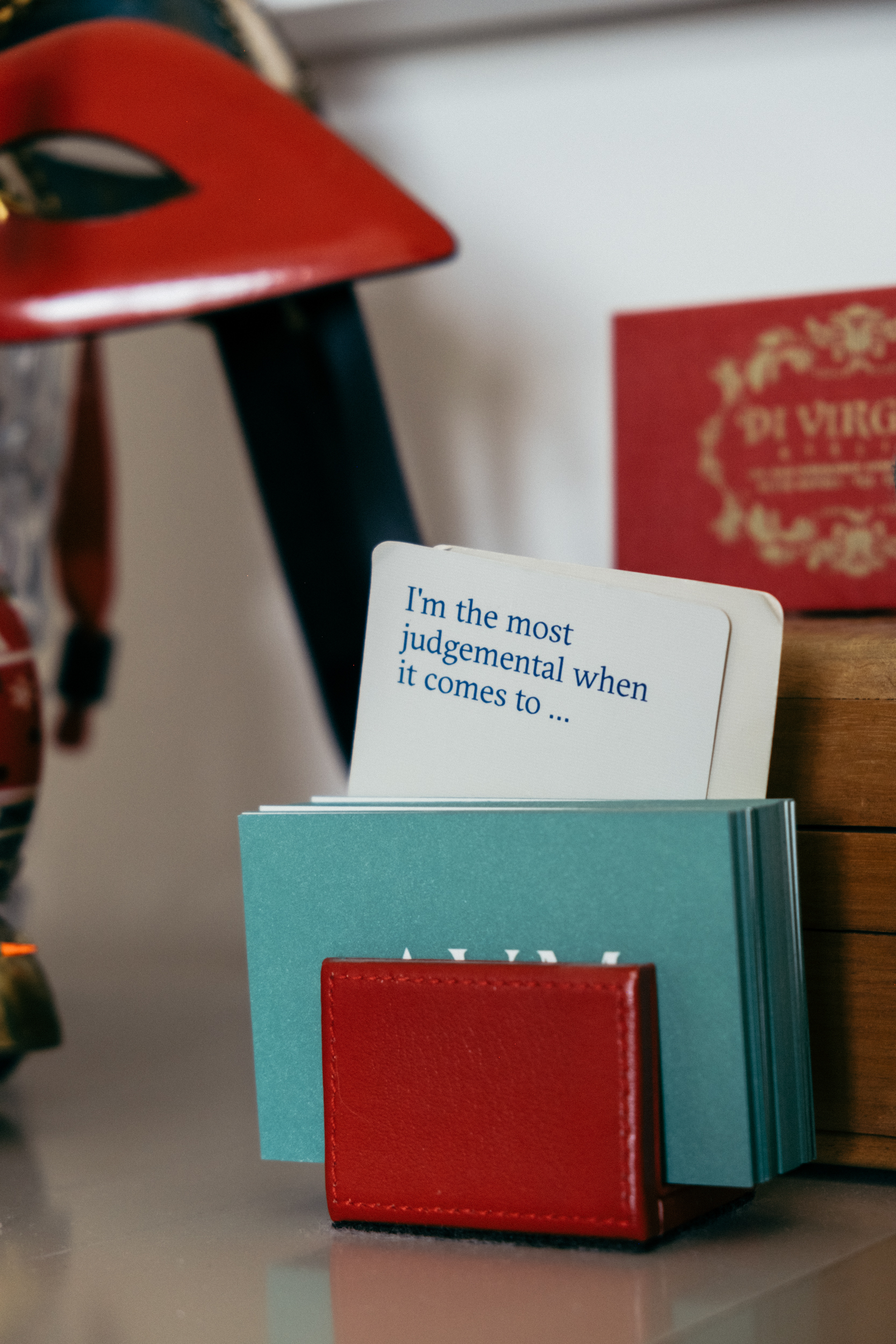 A close up of business cards, a red soled mask and trinkets