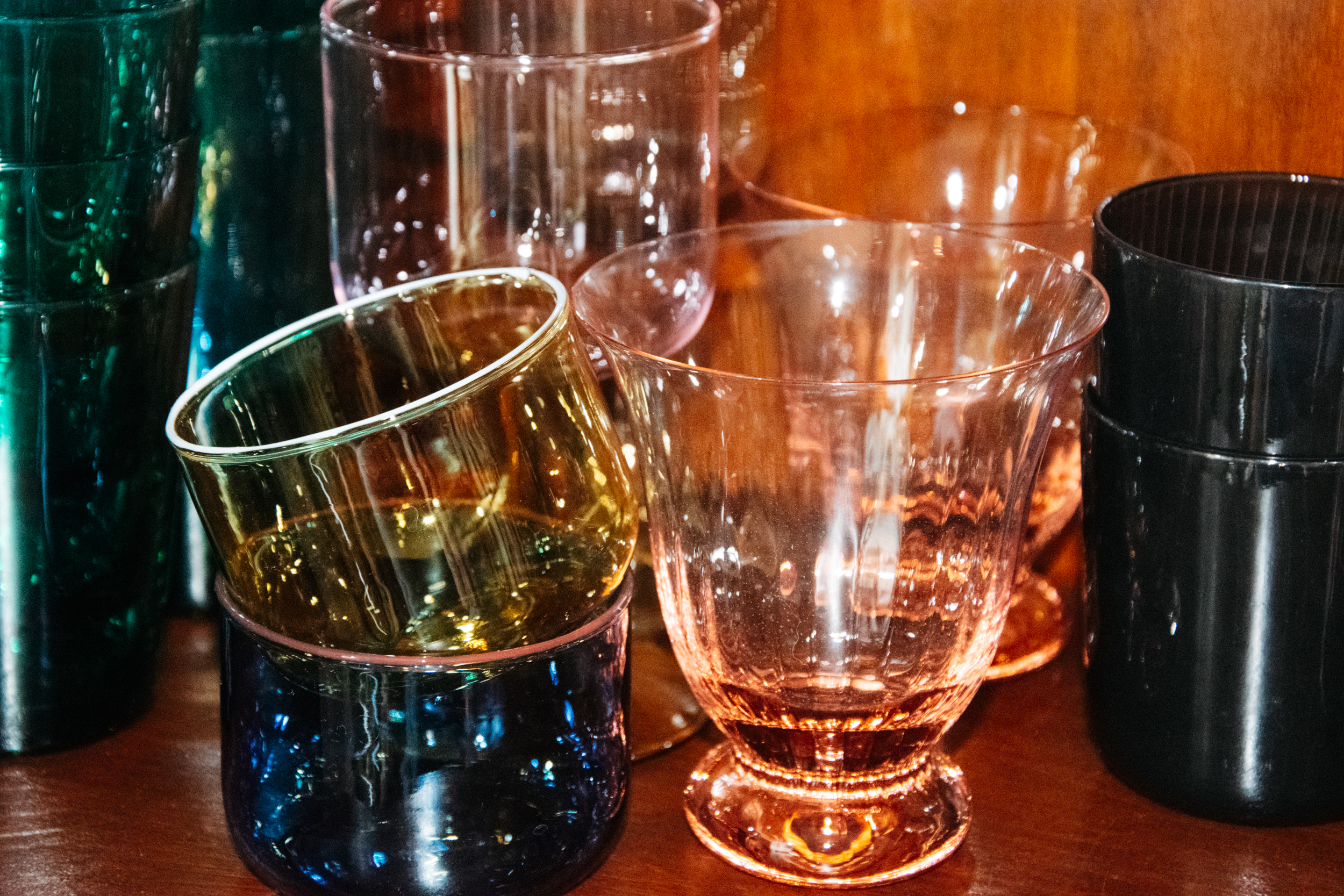 Close upshot of stacked coloured water glasses 