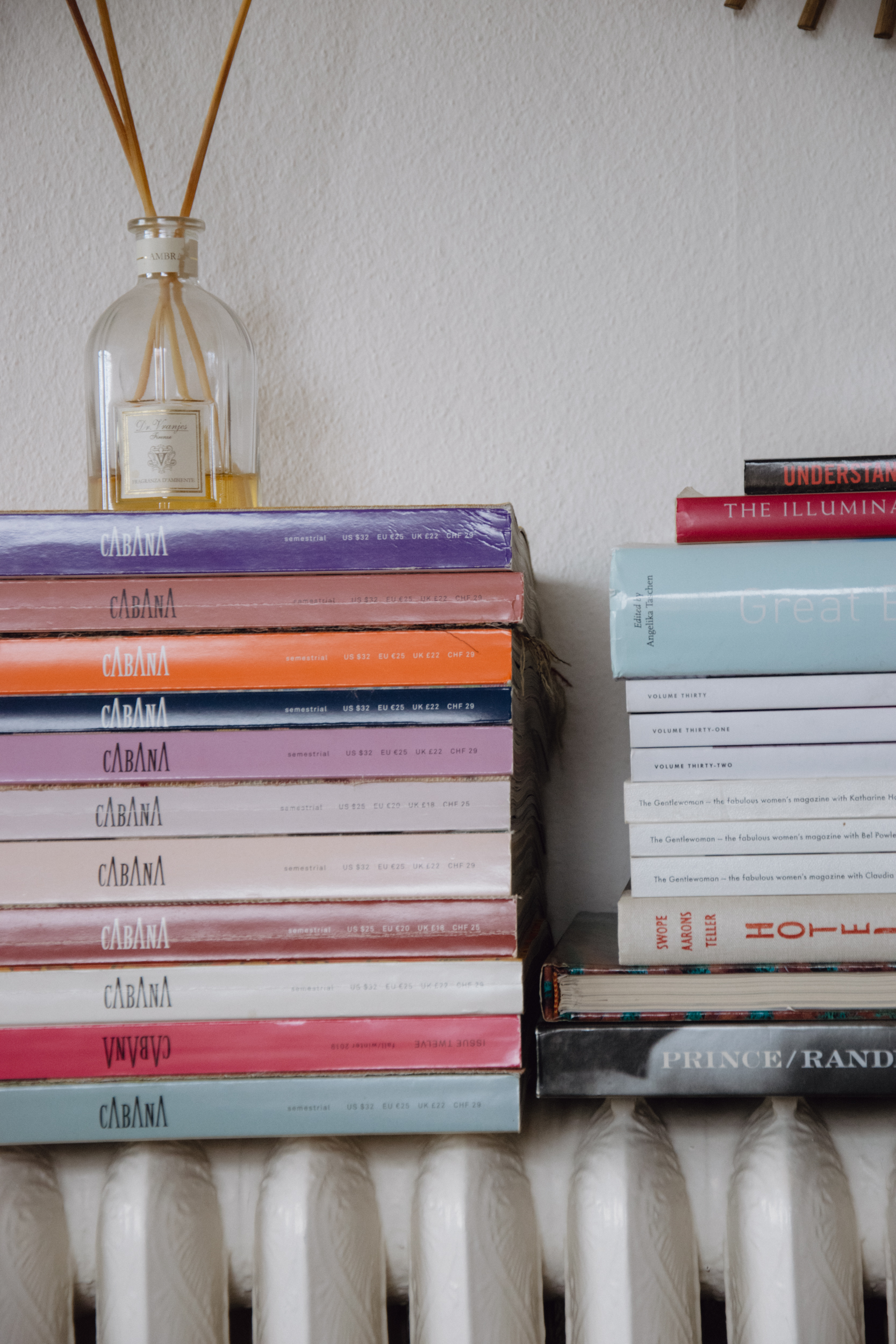 A pile of cabana magazines next to a stack of books 