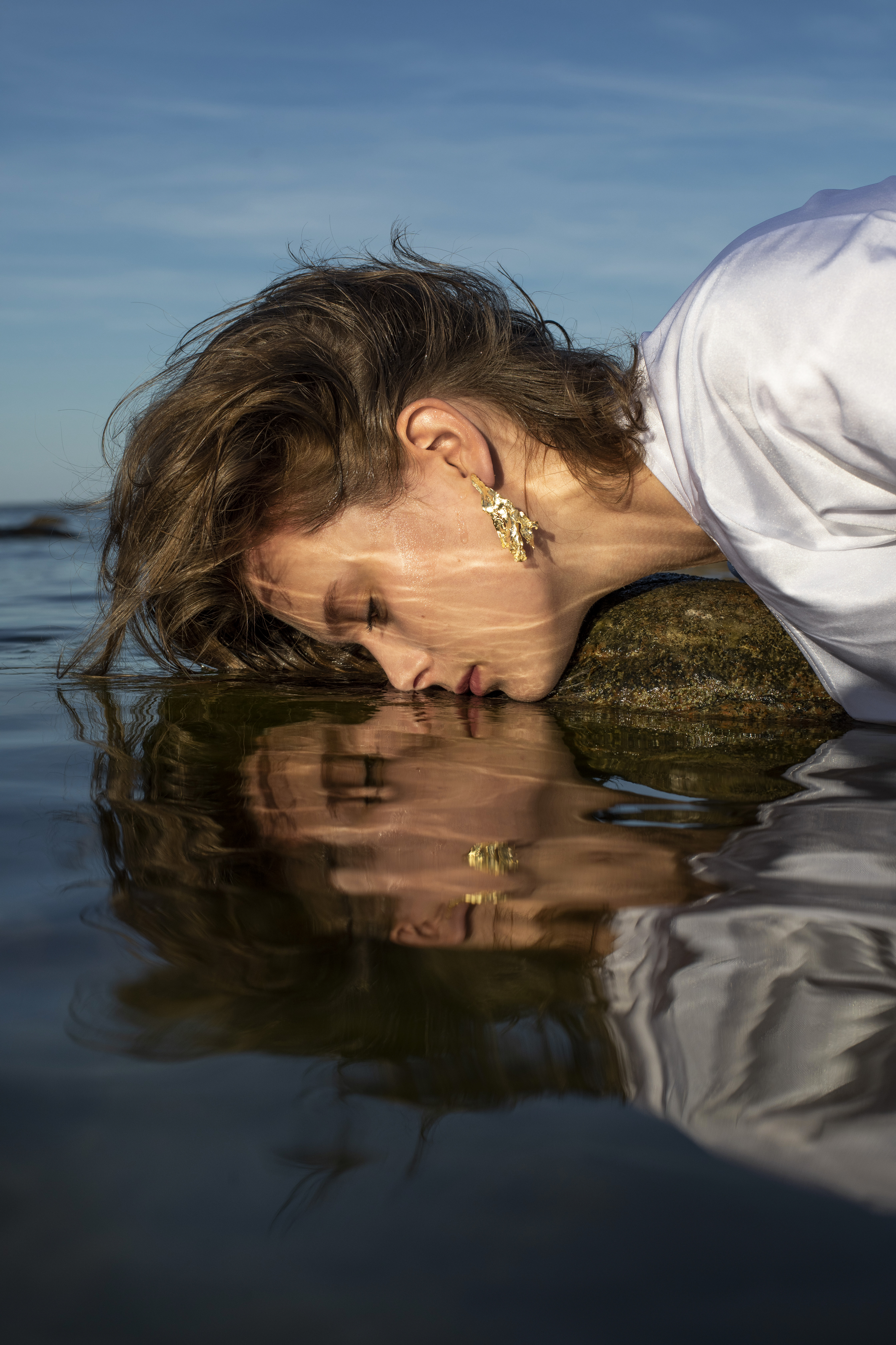 a woman photographed with lips against still waters by Julia Astok