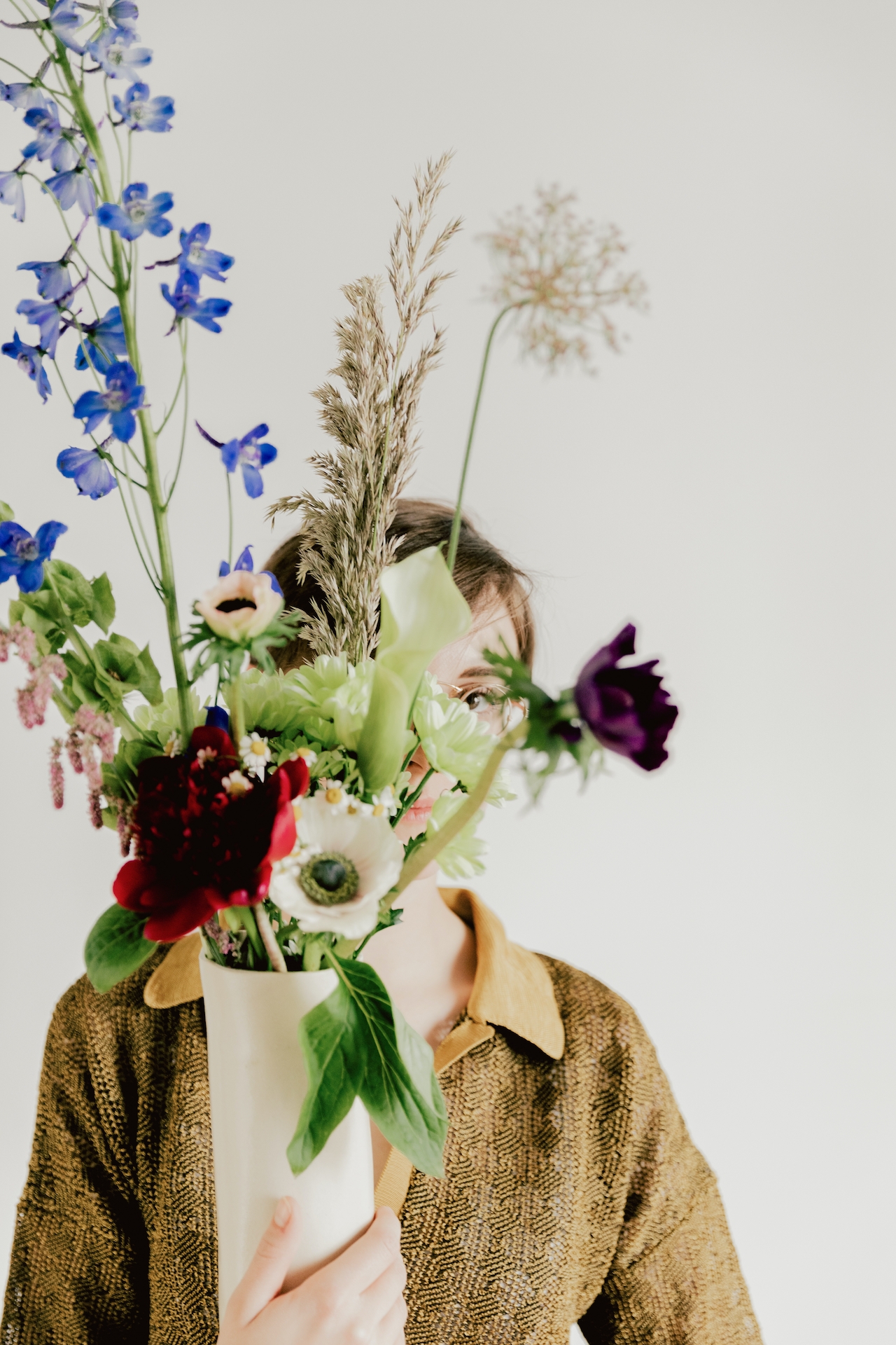 A man hiding behind a bouquet of flowers 