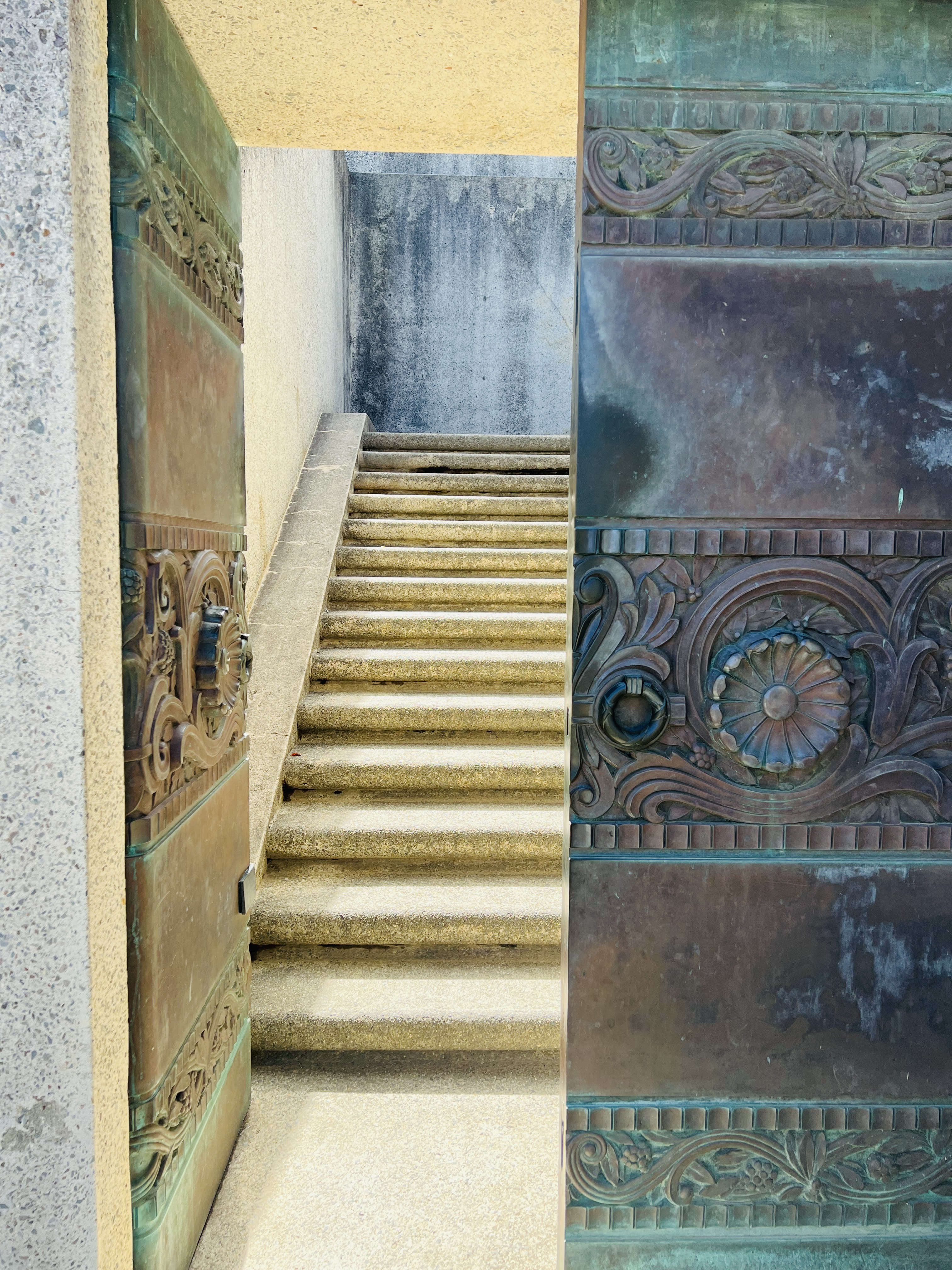 A picture of a beautiful door, ajar, and revealing a staircase going up a few steps behind it. 