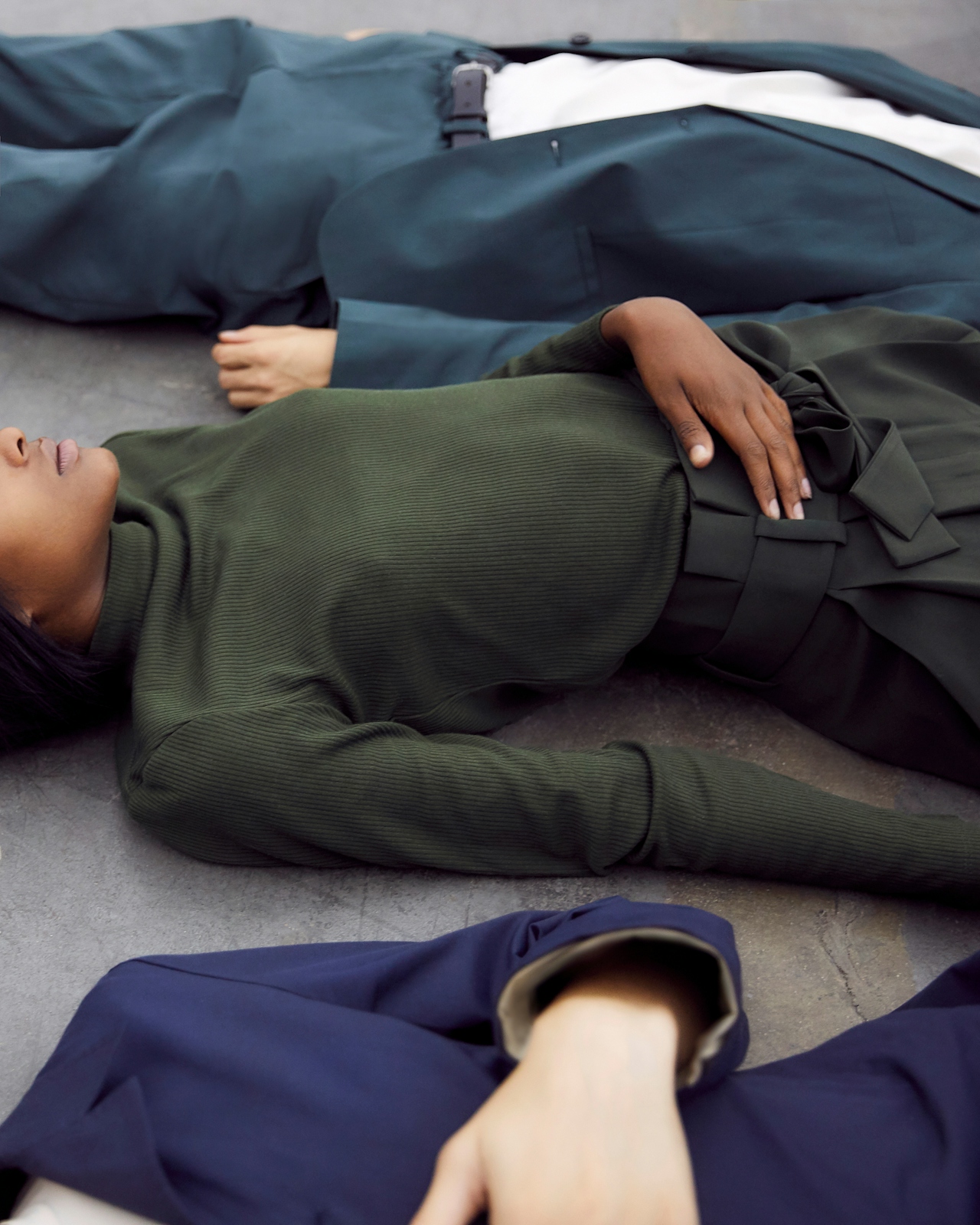 An image depicting three people lying on the floor with a hand on their belly in some kind of relaxation mode
